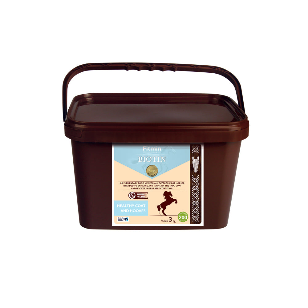 A 3kg brown bucket of Fitmin Biotin supplementary food mix for horses. The label features a light blue and cream design with a rearing horse silhouette, stating it is intended to enhance and maintain healthy skin, coat, and hooves. It includes the Fitmin Faktor and provides approximately 200 doses.